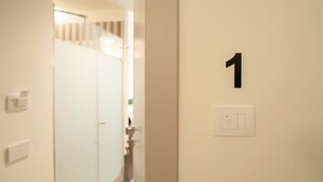 A hallway with a door marked with the number 1. - Maison Petronilla (Naples)