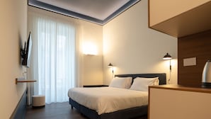 A modern hotel room with a bed, bedside lamps, a flat-screen TV mounted on the wall, and a wooden floor. - Maison Petronilla (Naples)