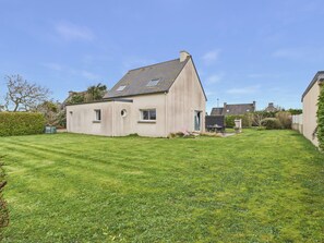 A single-story house with a sloped roof, a small front porch, and a well-maintained lawn. - Beach 200m away, house for 6 with garden (Guissény)