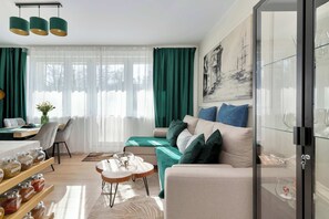 Een moderne woonkamer met een bank, een eettafel en een glazen kast.