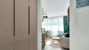 A modern living room with a sofa, a coffee table, and a bookshelf. - Comfortable Apartment in Gdansk | Balcony | Workspace (Gdańsk)
