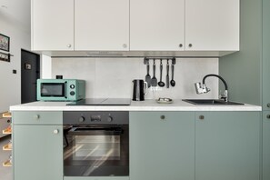 Een moderne keuken met een inbouwoven, een magnetron en een spoelbak met een kraan.