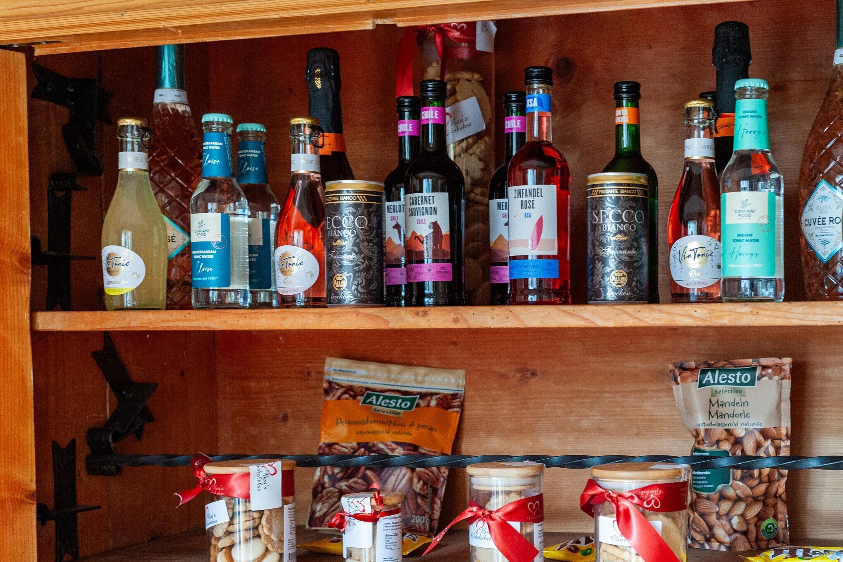 A wooden shelf with various bottles and jars, including wine and spirits.