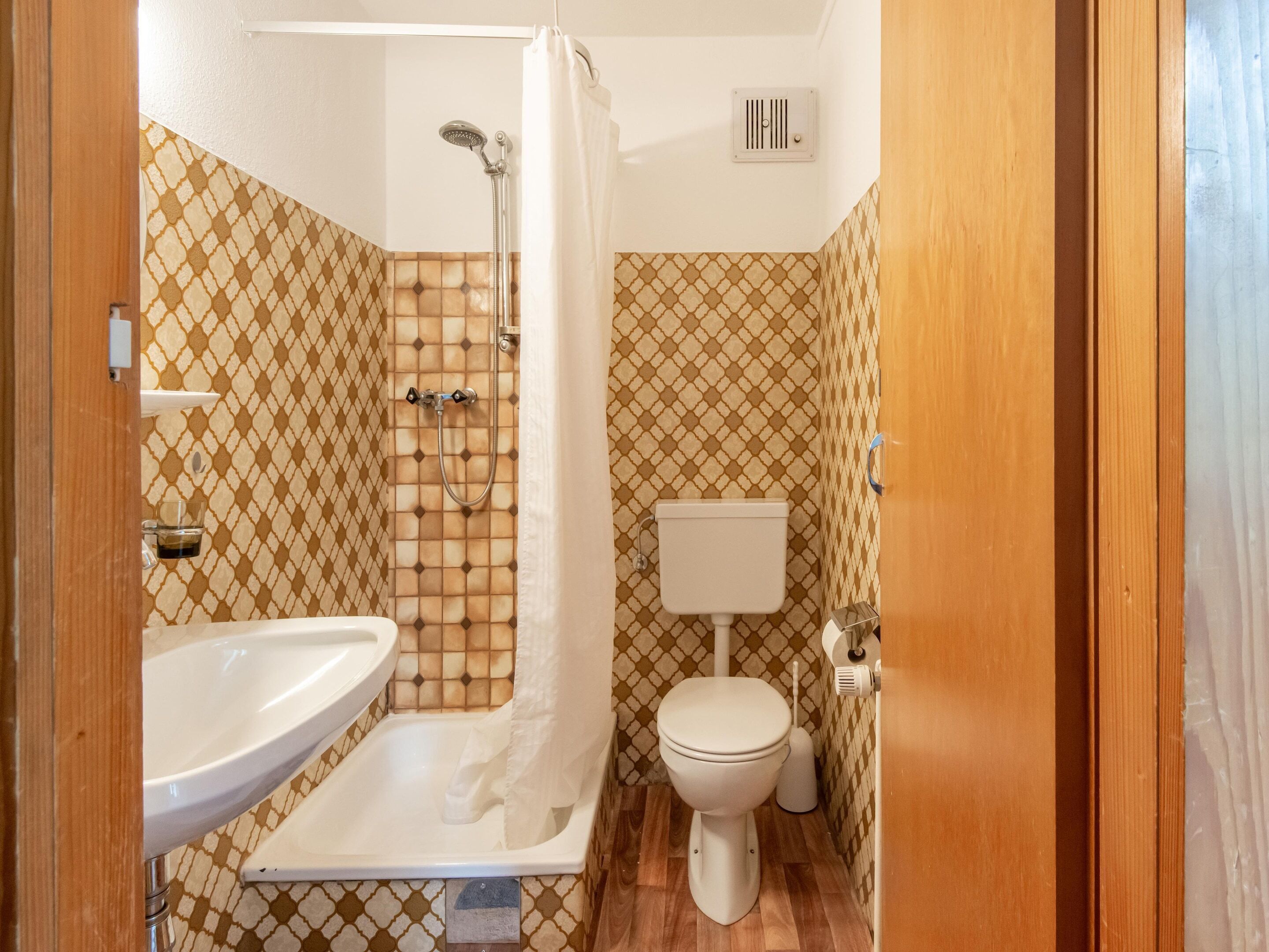 A bathroom with a shower, toilet, and sink.