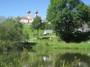 Eine friedliche Seeblick mit einer Kirche im Hintergrund, deren Turm zwei Kuppeln trägt.