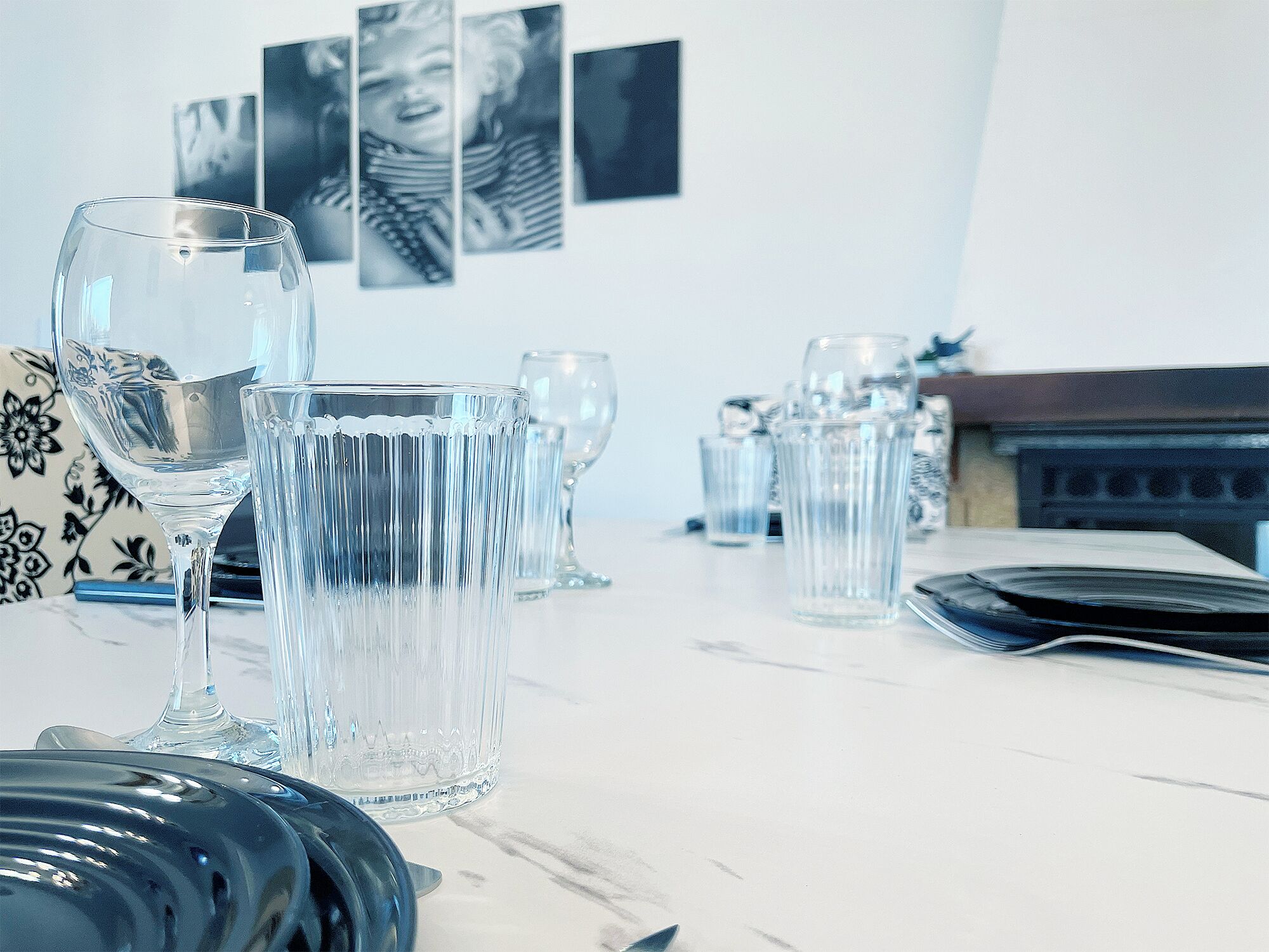 A dining table with clear glassware and a patterned vase.