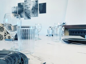 Une table à manger avec de la vaisselle transparente et un vase décoré de motifs.