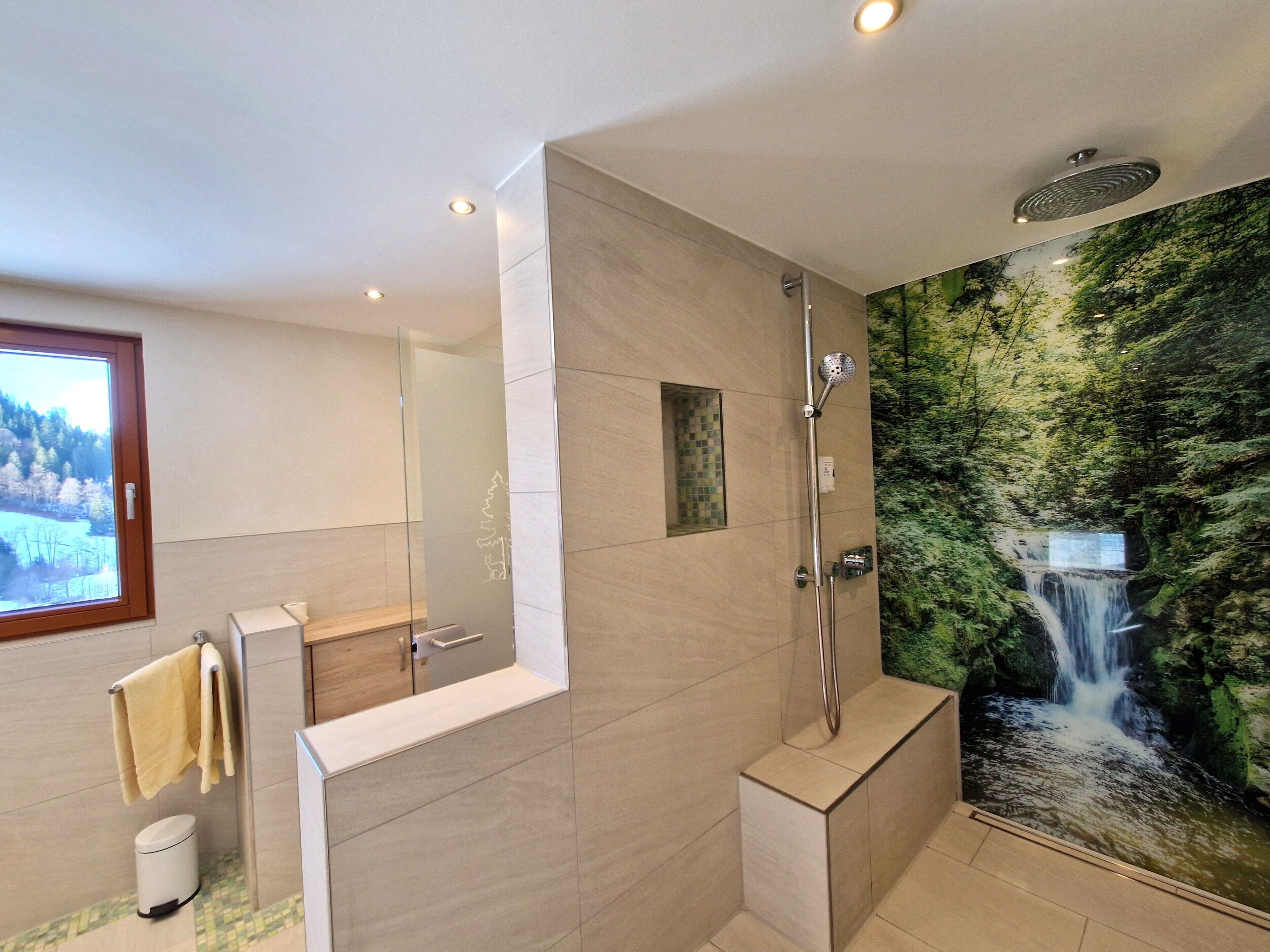 A modern bathroom with a shower, a toilet, and a sink.