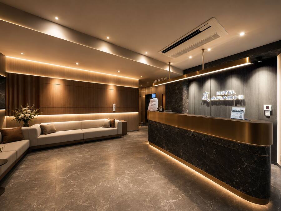 A modern hotel reception area with a reception desk, a sofa, and a wall-mounted TV.