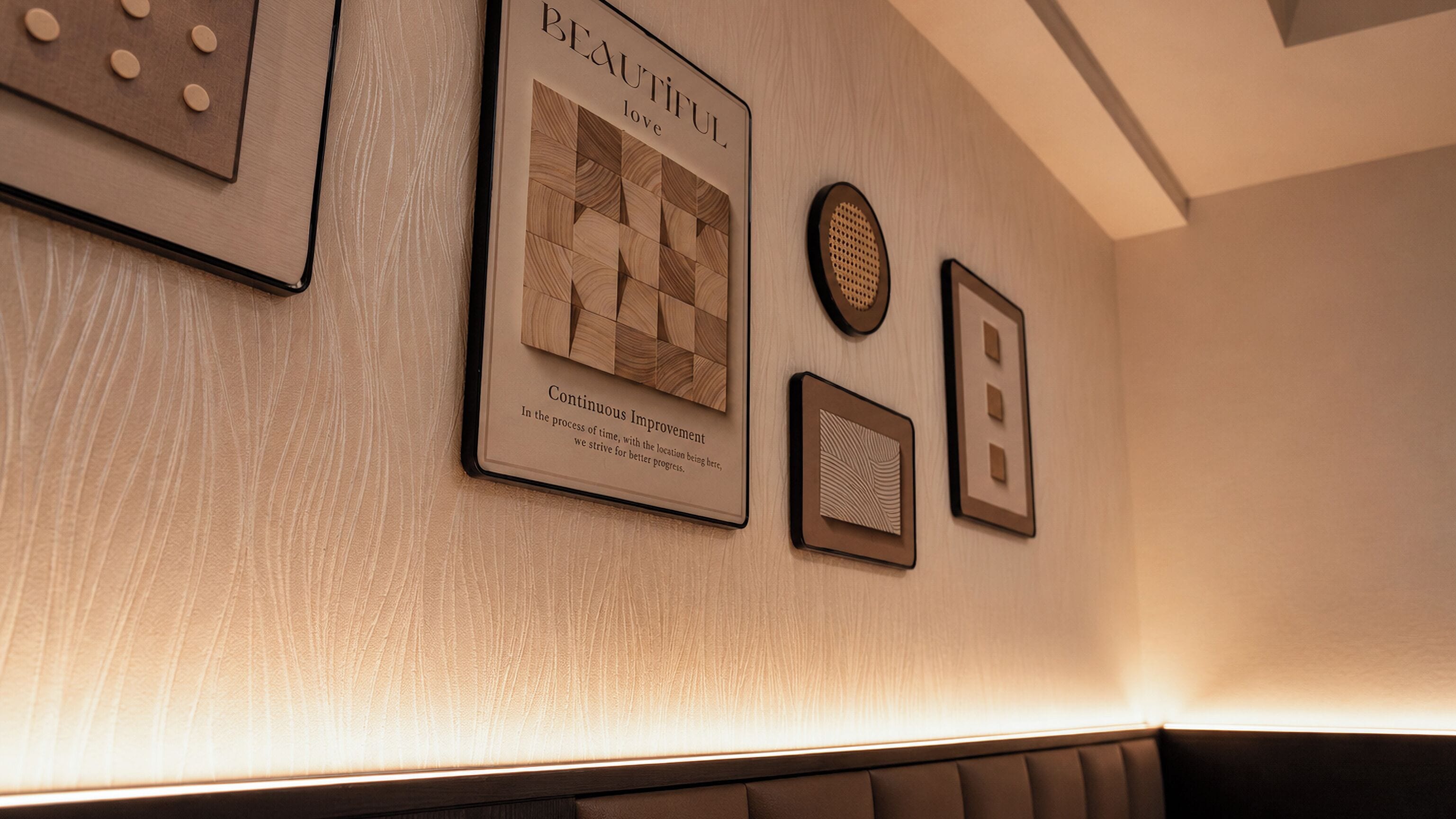 A wall with framed artwork, including a piece titled 'Continuous Improvement.'