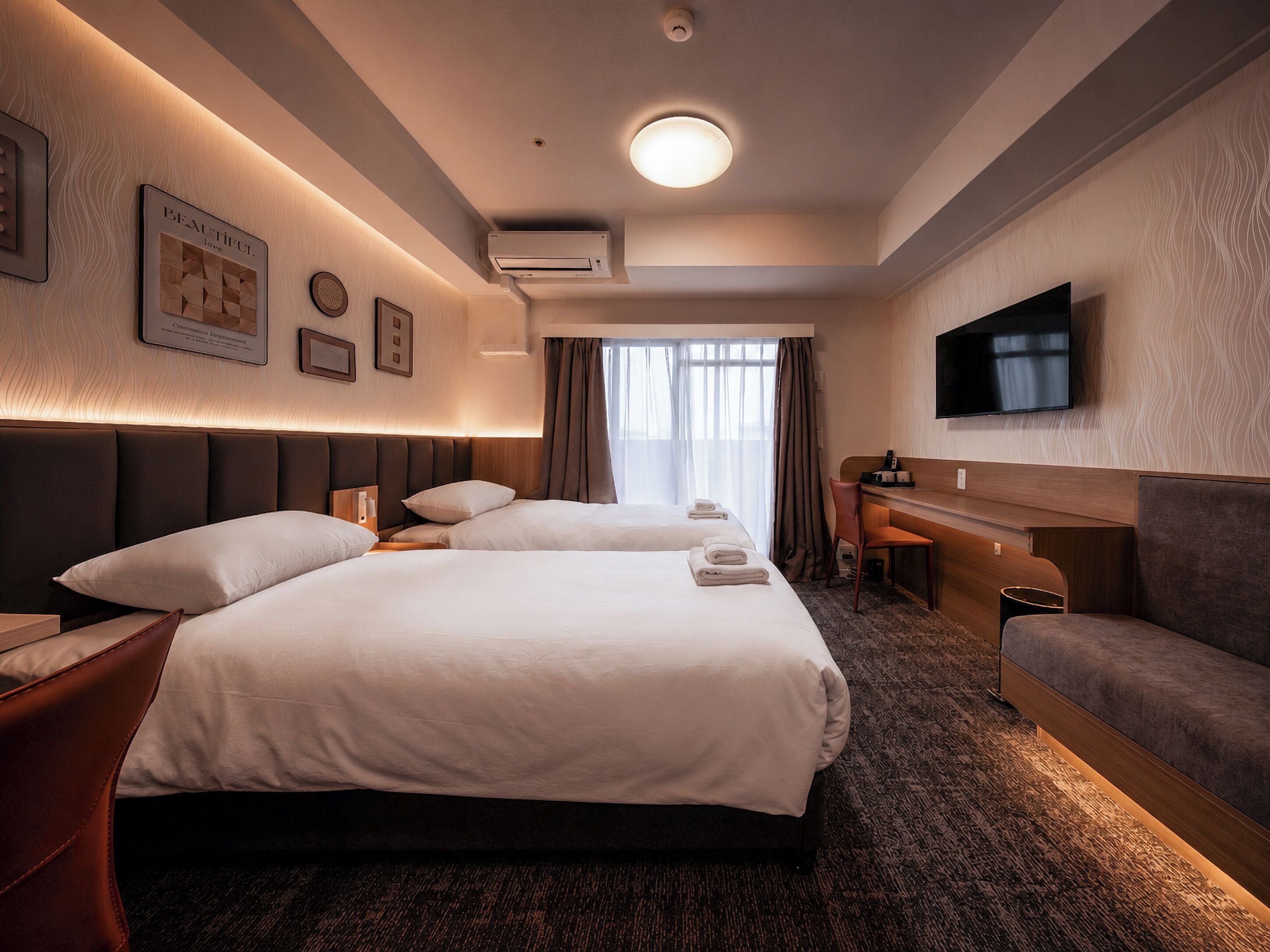 Une chambre d’hôtel avec deux lits, un bureau, un canapé, une télévision et une fenêtre avec des rideaux.