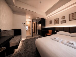 A hotel room with a bed, a sofa, a desk, and a bathroom visible through an open door. - Hotel Arashi Nihombashi Branch 2 (Osaka)