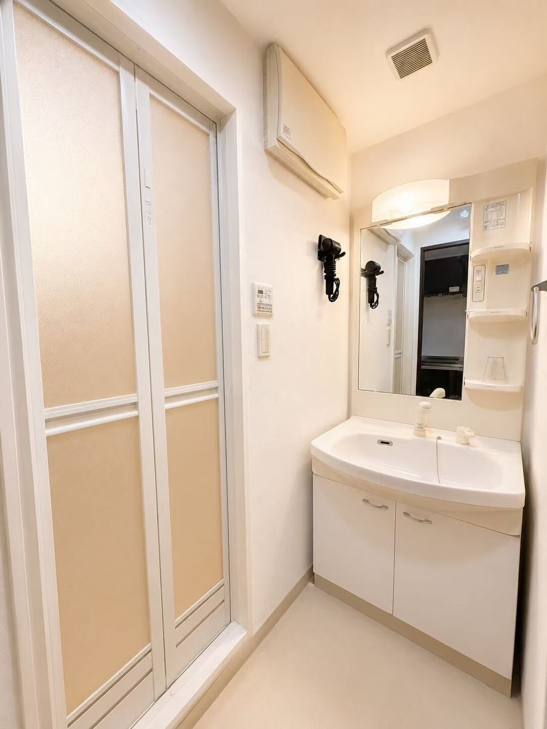 Une salle de bain avec un lavabo blanc, un miroir et un porte-serviettes.