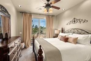 A bedroom with a bed, dresser, ceiling fan, and a view through the window. - Relaxing Sedona Hiking HQ, View, West Sedona! Star (Sedona)