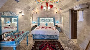 Ein Zimmer mit einem großen Bett, einer Bank und einer dekorativen Decke.