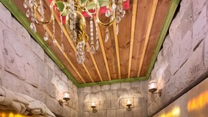 Ein Spa-Bereich mit freistehender Badewanne, Steinwänden und Holzboden.