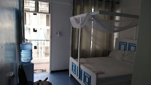 A room with a bed, a water dispenser, and a view of the outside. - Kisiwa Boutique Hotel Mombasa (Mombasa)