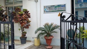 A gated courtyard with potted plants, a sign for Boutique Hotel, and air conditioning units on the wall. - Kisiwa Boutique Hotel Mombasa (Mombasa)