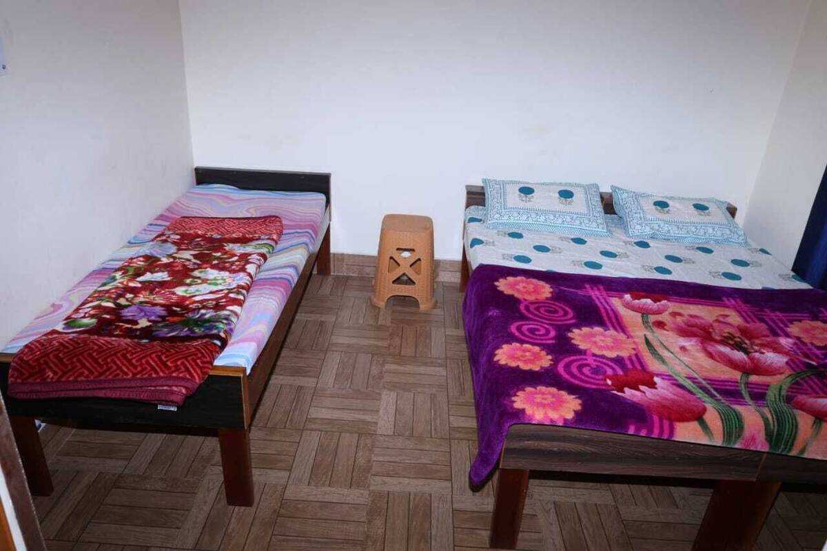 A room with two single beds, each with a distinct patterned bedspread.