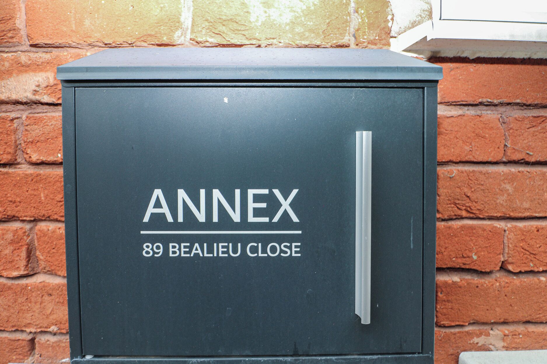 Een zwarte metalen brievenbus met de tekst 'ANNEX 89 BEALIEU CLOSE'.