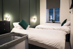 1 quarto, escrivaninha, ferros/tábuas de passar roupa, berço de viagem