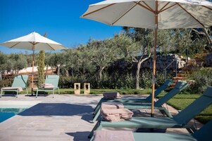 Una piscina al aire libre de temporada, sombrillas