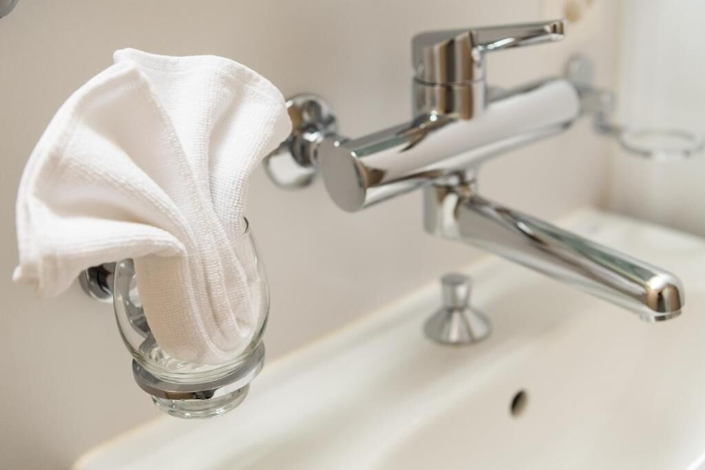 Une salle de bain avec un robinet chromé et un porte-savon en verre.