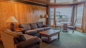 Una habitación acogedora con detalles de madera, un sofá, una mesita de centro y vistas al exterior.