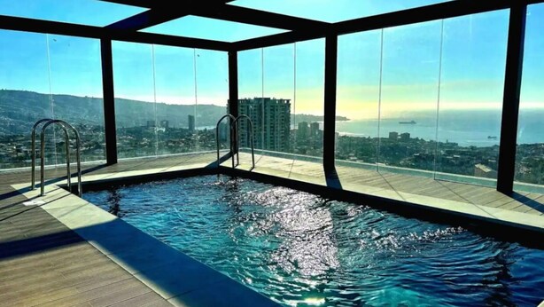 Ein Infinity-Pool auf dem Dach bietet einen ungehinderten Blick auf die Stadtlandschaft und den Ozean.