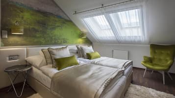 A bedroom with two beds, a green armchair, a small round table, and a large abstract painting on the wall.