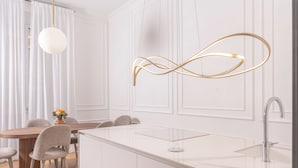 A modern kitchen with a central island, white cabinetry, and a pendant light. - N9 Tacito Design (Rome)