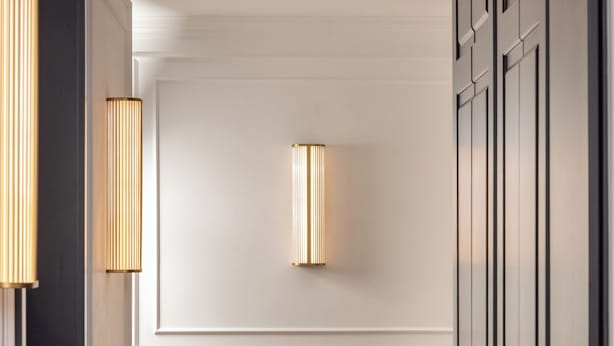 A hallway with wooden flooring, white wainscoting, and a black rabbit sculpture. - N9 Tacito Design (Rome)