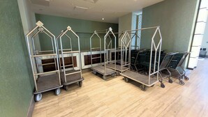 Een hotelhal met metalen karren en een zithoek.