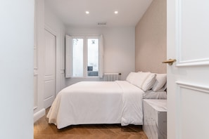 Ein Schlafzimmer mit Bett, Heizkörper und Fenster.