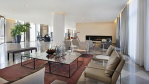A spacious lobby with a modern design, featuring a seating area with sofas and a coffee table, a reception desk, and a fireplace. - Hotel Berlin Potsdamer Platz by Leonardo Hotels (Berlin)