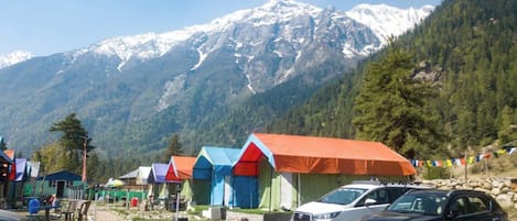Una fila de carpas coloridas con montañas al fondo.