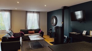 Een moderne woonkamer met een bank, salontafel en een open haard.