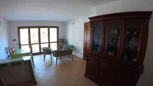 Una habitación amplia con comedor, un armario grande y televisión.