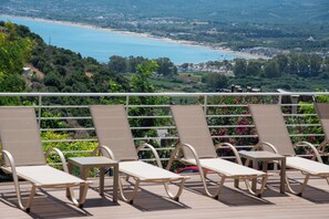 A terrace with sun loungers overlooking a coastal view. - Stardust Rooms and Apartments (Exopoli)