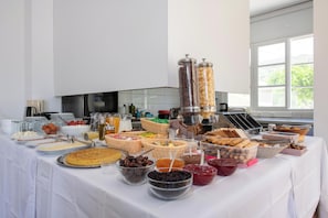 A buffet table with various food items and condiments.