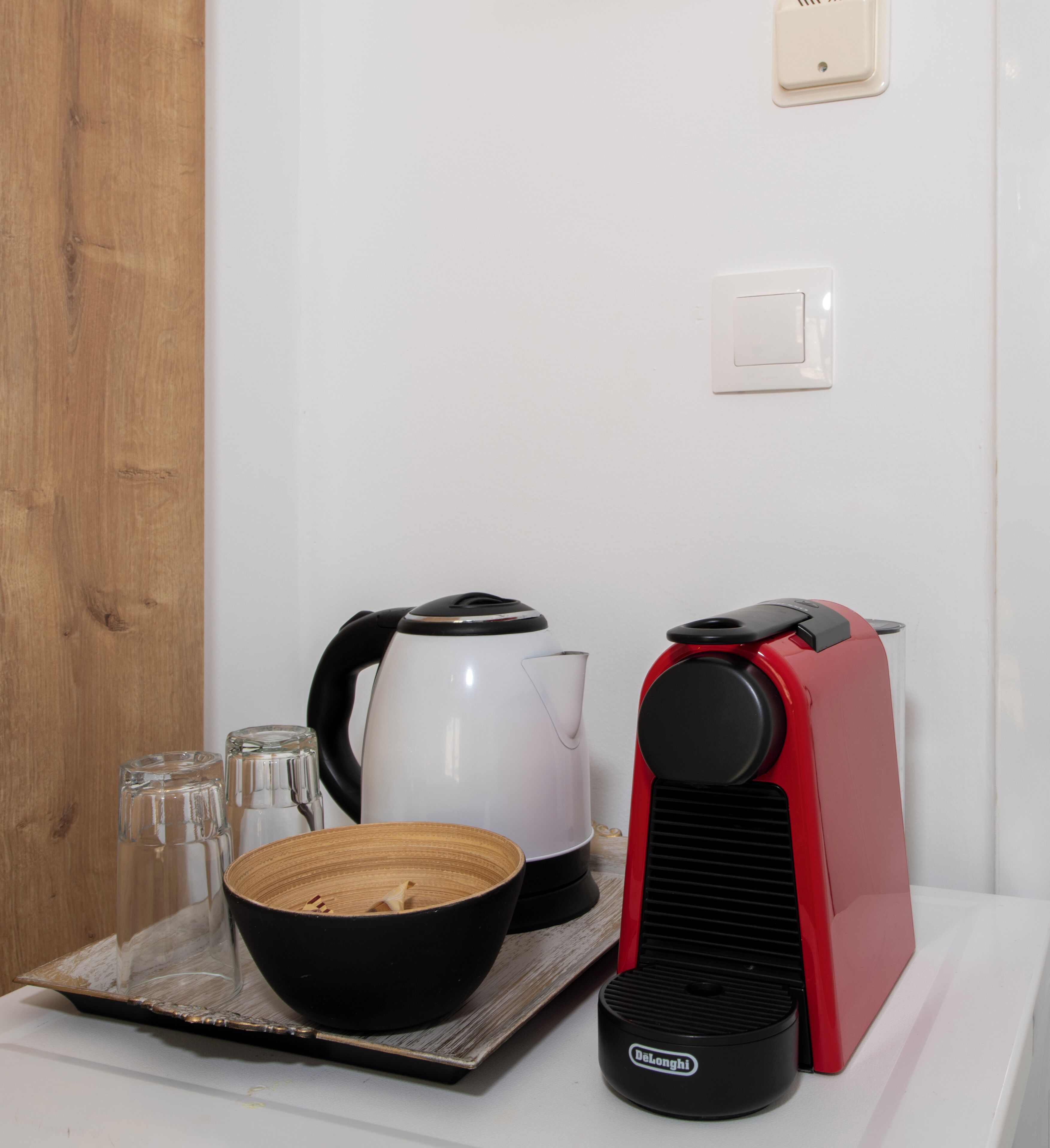 Eine Küche mit Kaffeemaschine, Wasserkocher und einer Schüssel auf einem Tablett.