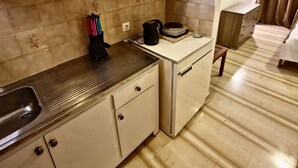 A compact kitchen with wooden cabinets, a sink, and a countertop.