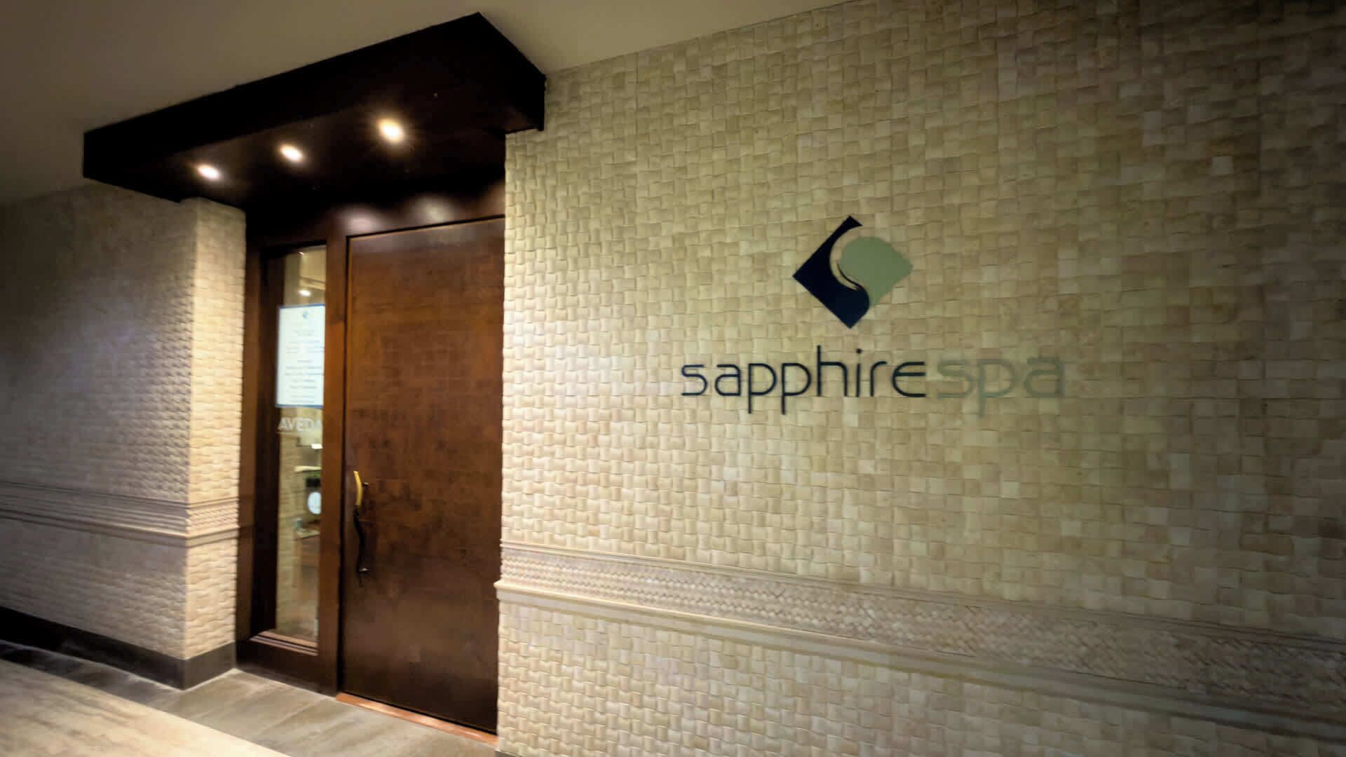 A spa entrance with a textured wall and a logo for 'sapphire spa'.