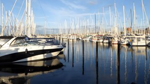 Un puerto deportivo con varias embarcaciones amarradas, agua tranquila y cielos despejados.
