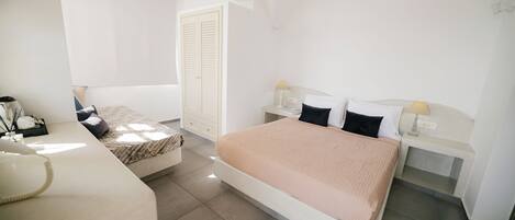 A bedroom with a bed, bedside tables, a desk, and a chair.
