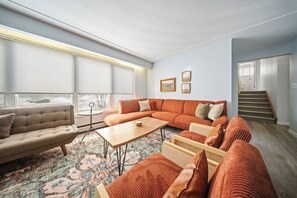A modern living room with a sectional sofa, a coffee table, and a patterned rug.