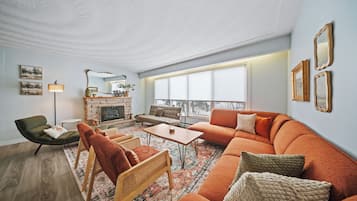Un salon moderne avec un canapé, des fauteuils, une table basse et une cheminée.