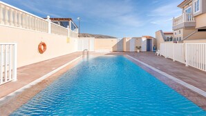 A swimming pool with a white fence, a lifebuoy, and a clear sky. - Casa Da Roca Medano - Beach House & Terrace (Granadilla de Abona)