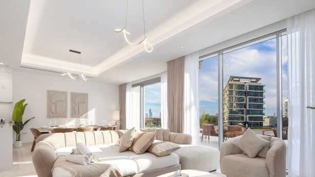 Ein modernes Wohnzimmer mit einer Couch, einem Essbereich und Blick auf eine Stadtlandschaft.
