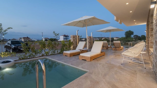 A rooftop pool area with lounge chairs and umbrellas, a swimming pool, and a view of the surrounding landscape. - Theano Sea Suite 3 by Travel Pro Services (Portaria)